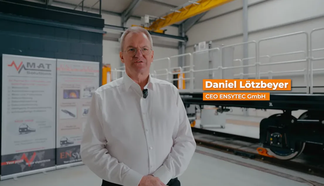 Daniel Lötzbeyer, Managing Director of ENSYTEC GmbH, in the production hall in front of a rail vehicle