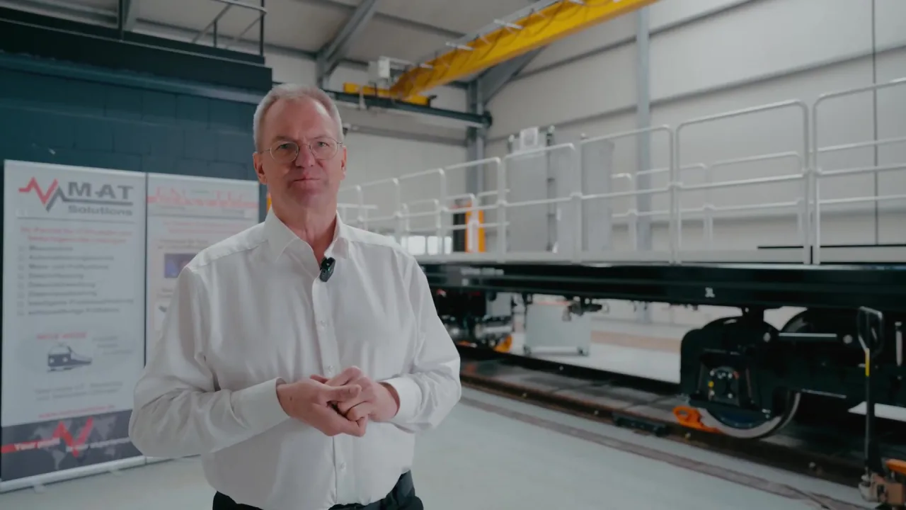 Daniel Lötzbeyer, Geschäftsführer der ENSYTEC GmbH, in der Fertigungshalle vor einem Schienenfahrzeug