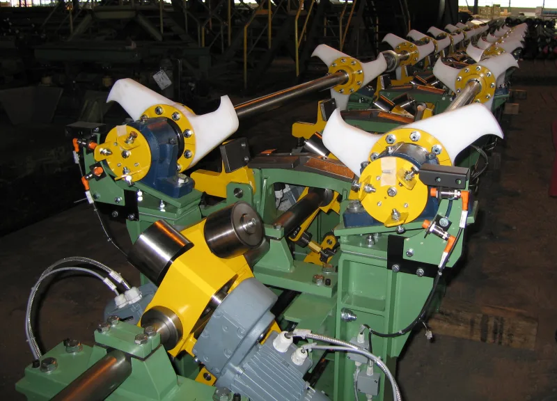 Centring stations with white plastic infeed funnels and driven rollers