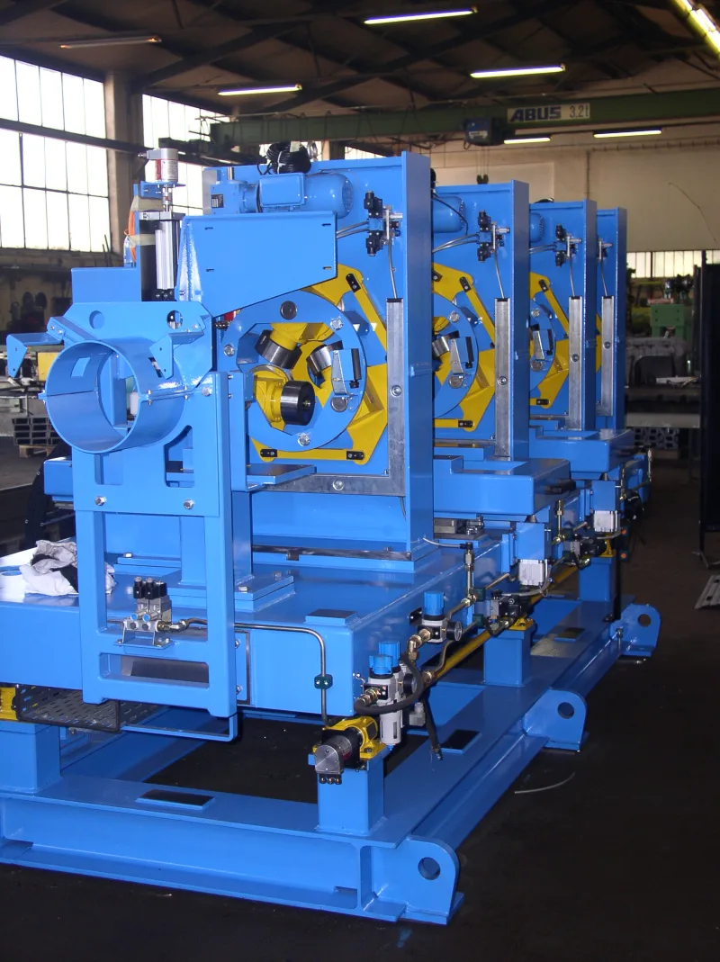 Four blue inspection modules with yellow rotating heads on a shared base frame in the workshop