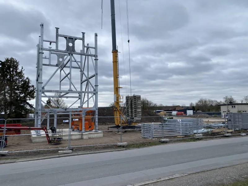 E-Parktower construction site with the erected steel frame, mobile crane and stacked steel profiles