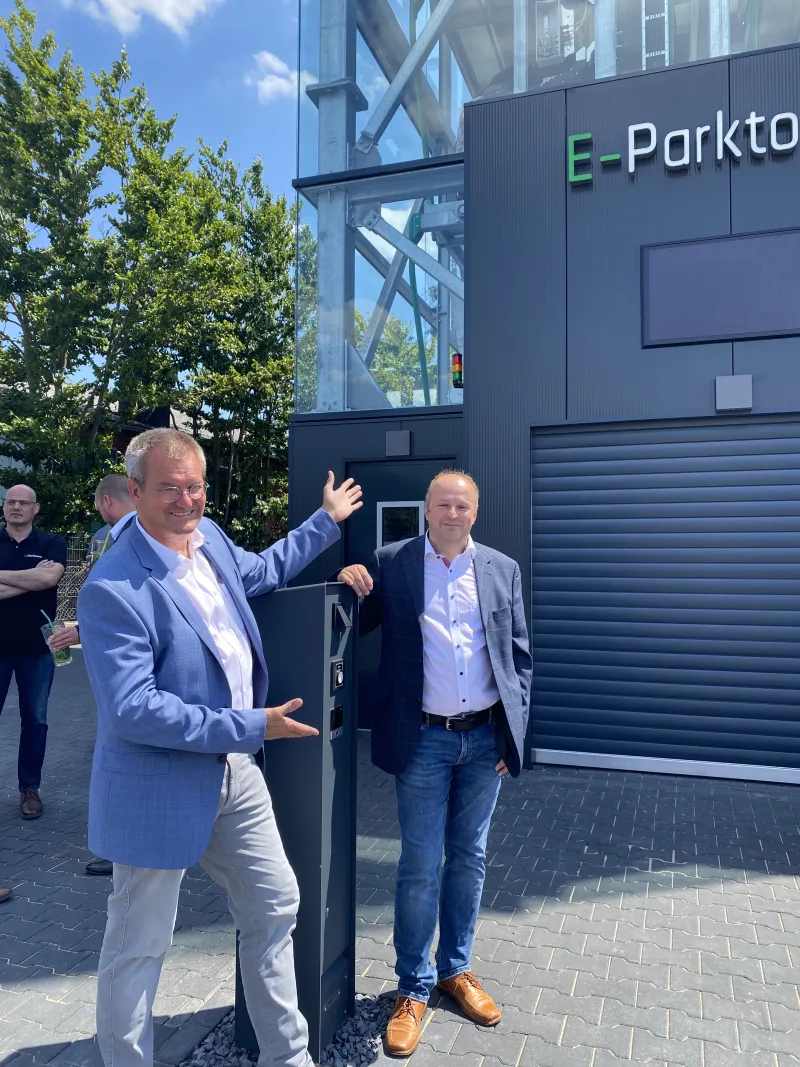 Two visitors talking in front of the completed E-Parktower